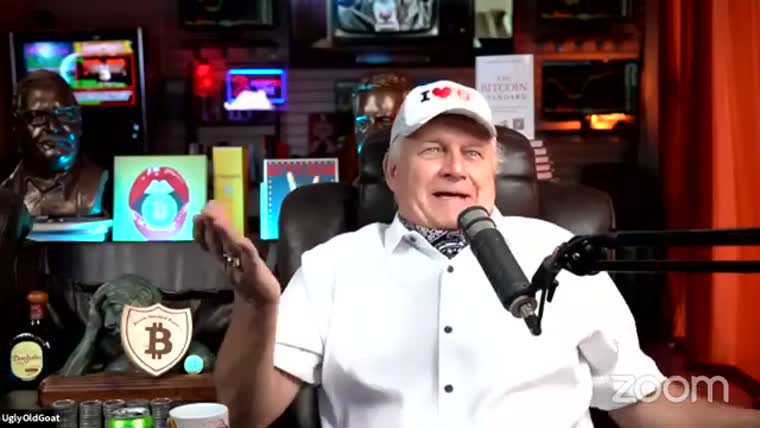A white-haired man in a white shirt and cap speaks into a
         microphone in a studio.