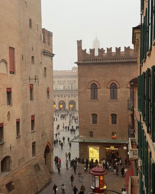 A narrow street opens onto a square between tall stone buildings.
